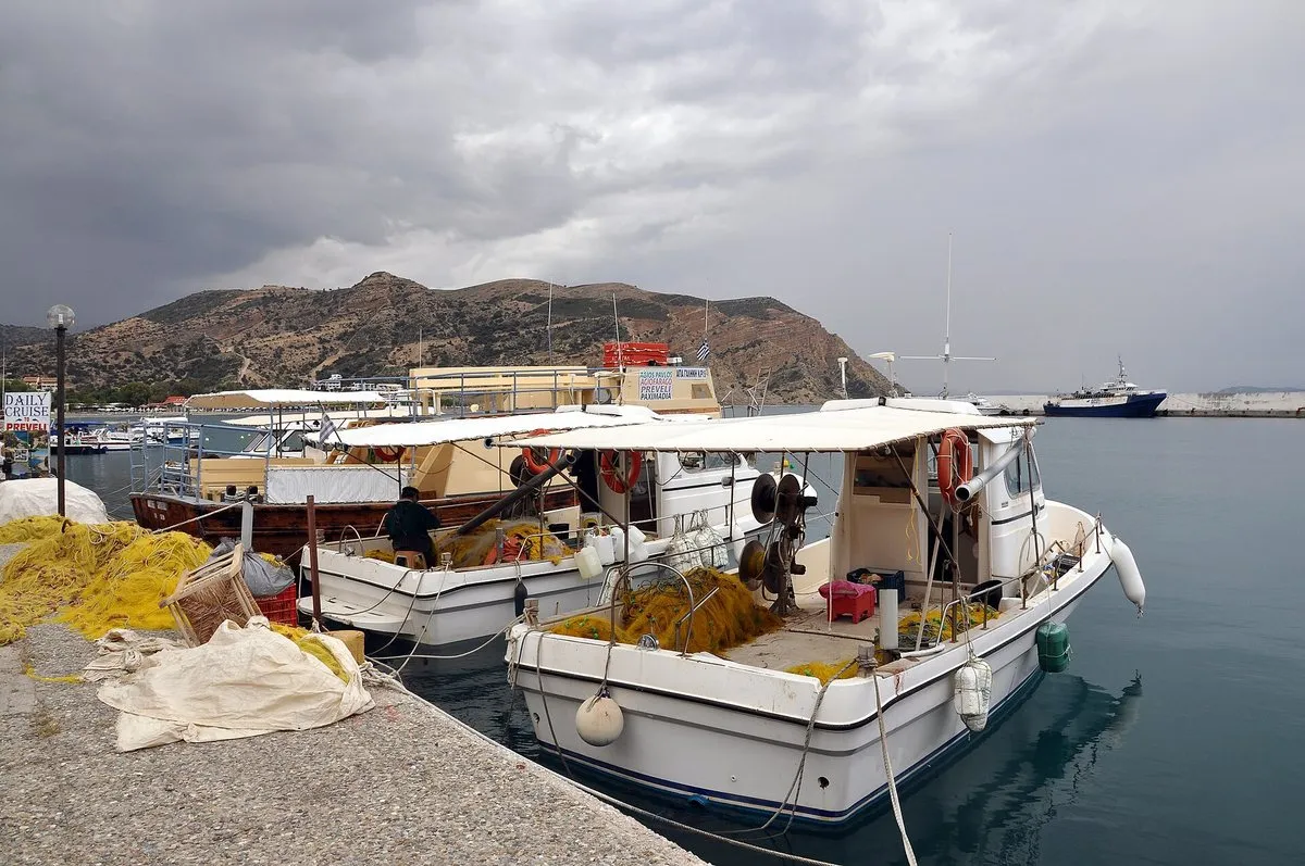 A fishing boat on the harbour quay under heavy sky