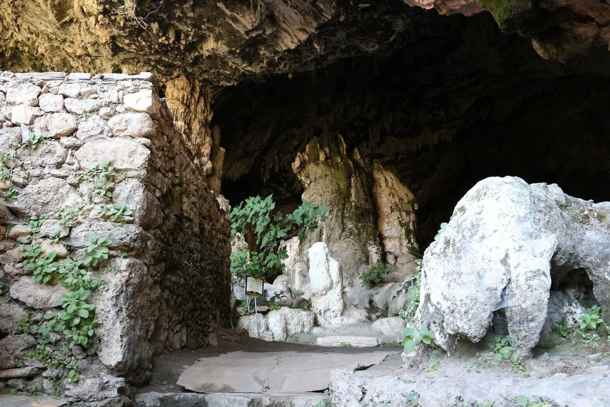 In der Höhle Agia Sofia, mit Steinmauern, dem Kapelleneingang und Stalagmiten