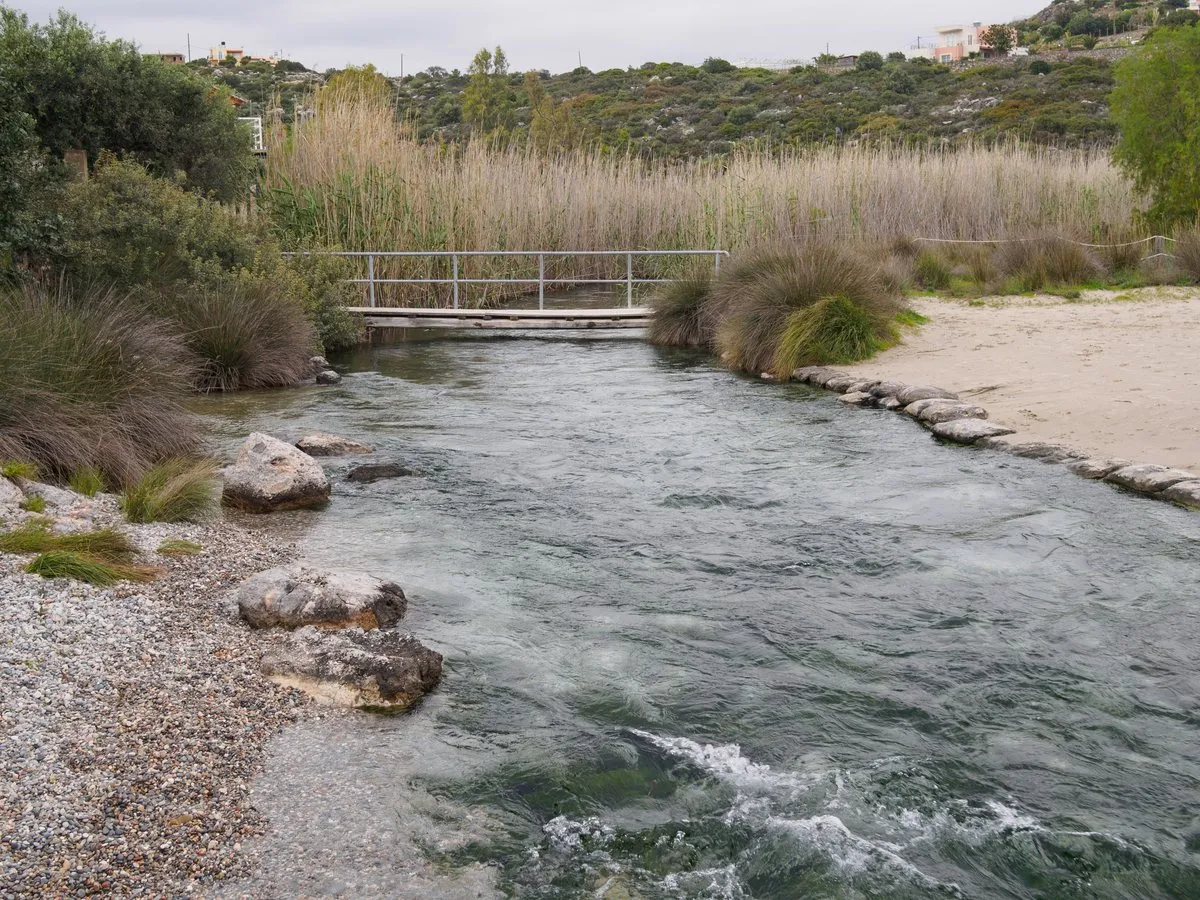Der Bach von Almyros fließt durch Schilf auf den Strand südlich von Agios Nikolaos zu