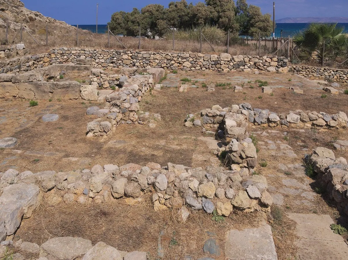 Niedrige minoische Mauern der Villa der Lilien in Amnissos, hinter dem Zaun das Meer