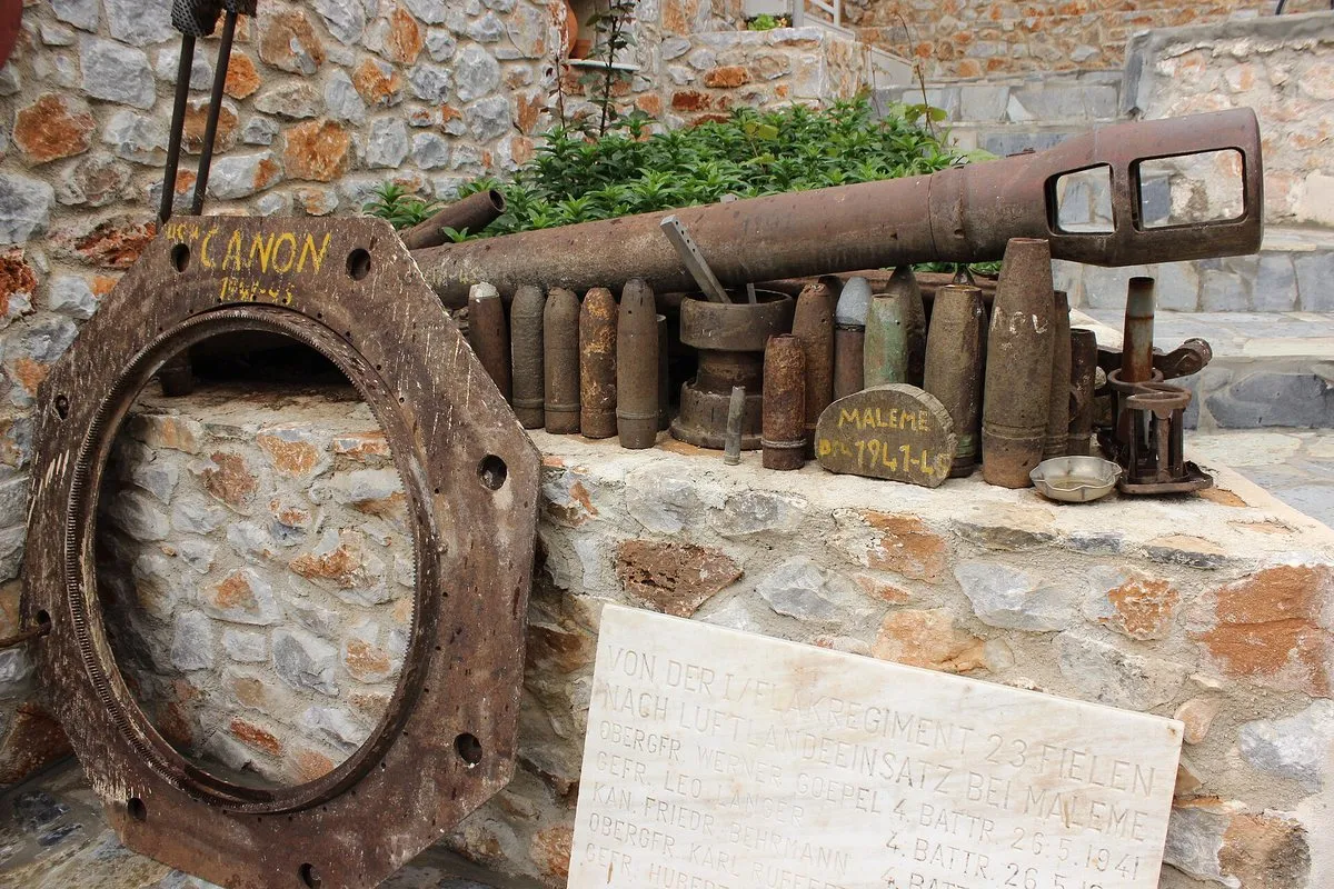 Rusted shells and a cannon barrel displayed on a stone wall at the museum