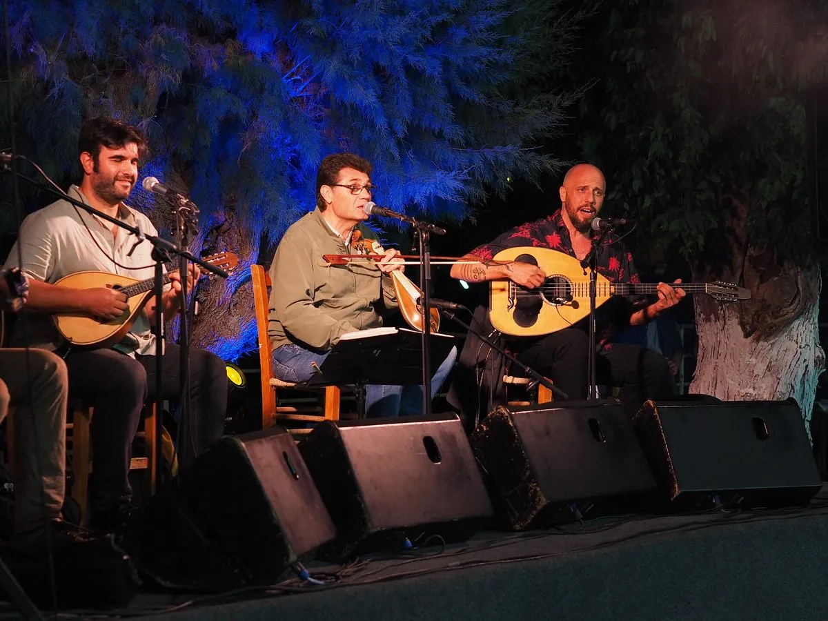 A Cretan music trio playing lyra, laouto and bouzouki at an outdoor festival