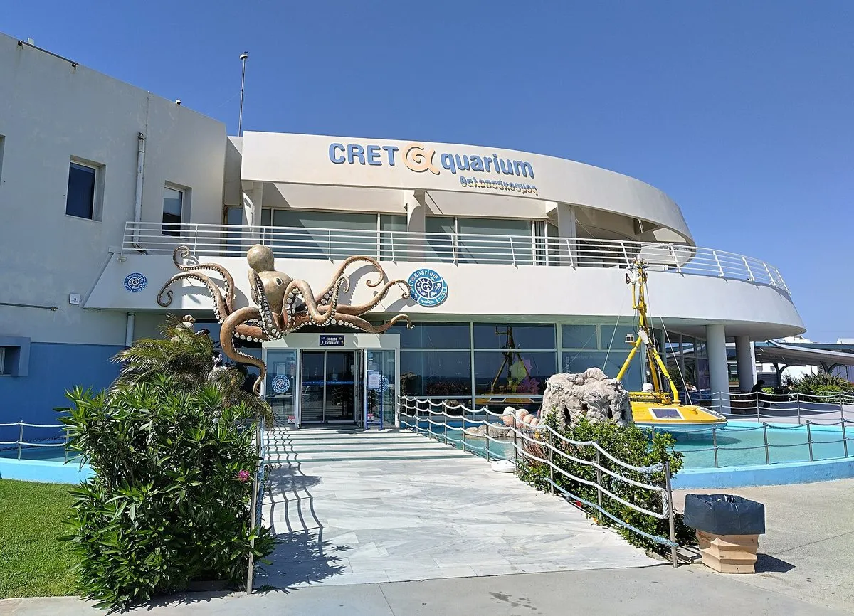 The entrance to the Cretaquarium at Gournes, with its octopus sculpture above the doors and an oceanographic buoy in the pool outside