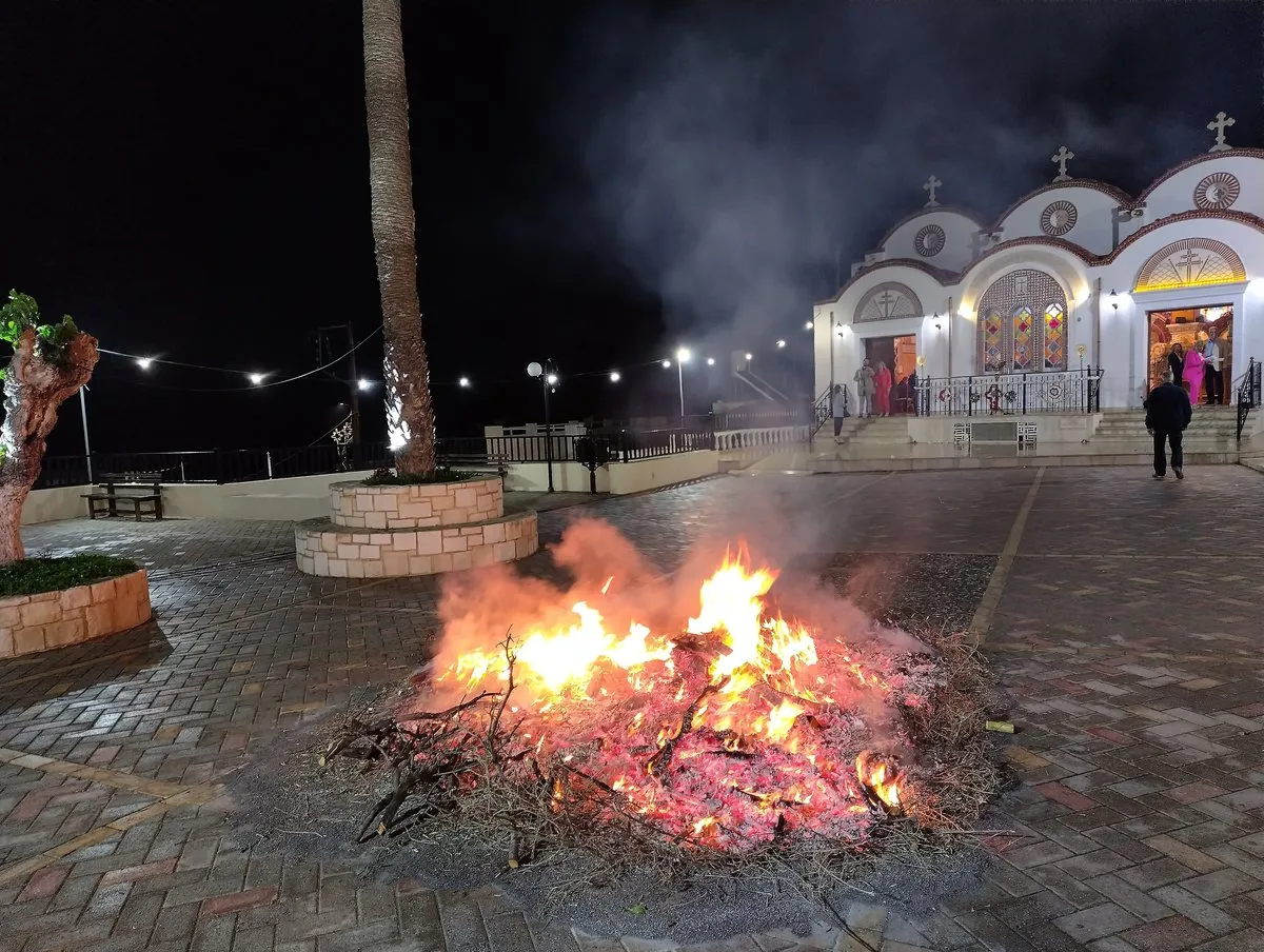 A Judas bonfire burning in the square in front of the lit church after midnight