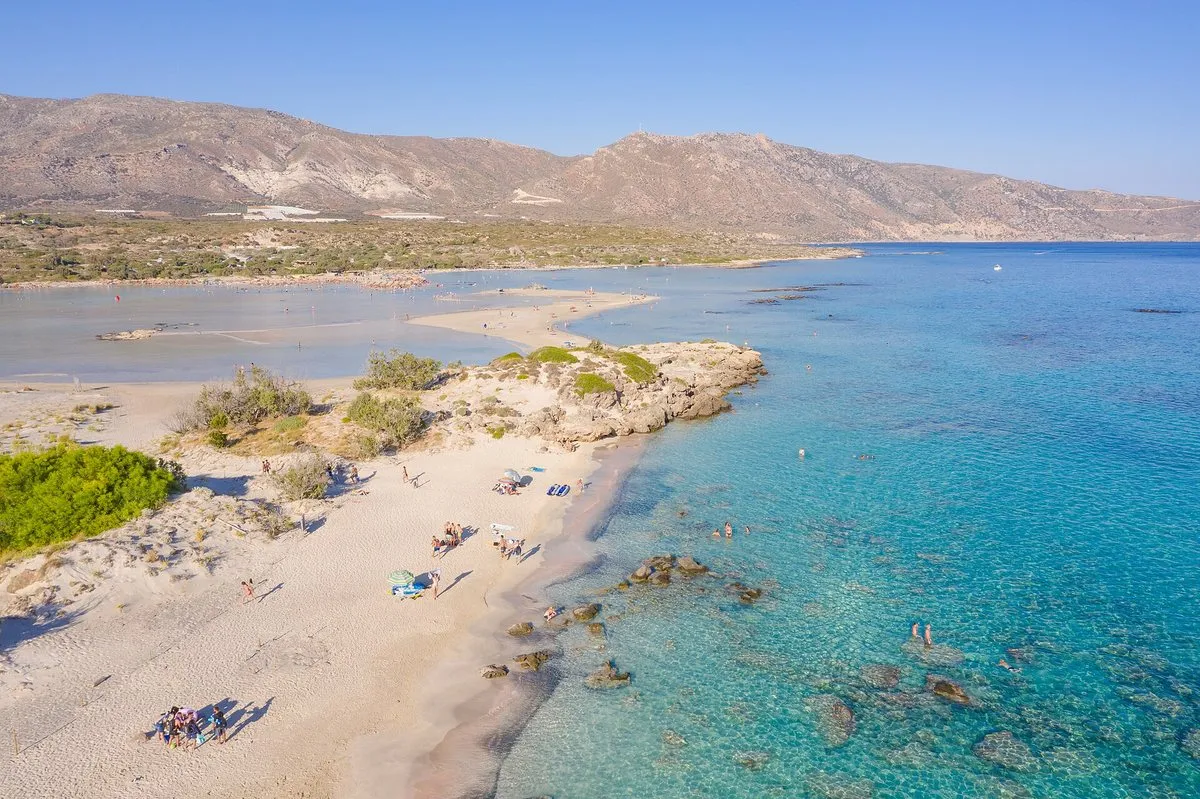 Luftbild von Strand und Lagune von Elafonisi mit dem Inselchen und türkisfarbenen Untiefen