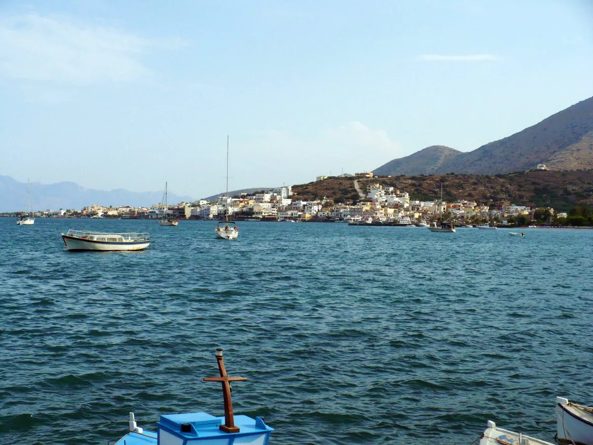 Elounda spread low along the water under its bare mountain, with boats at anchor