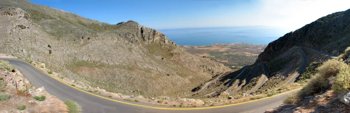 Die Straße von Kallikratis windet sich in Serpentinen über kahle Hänge hinab Richtung Ebene von Frangokastello und Meer