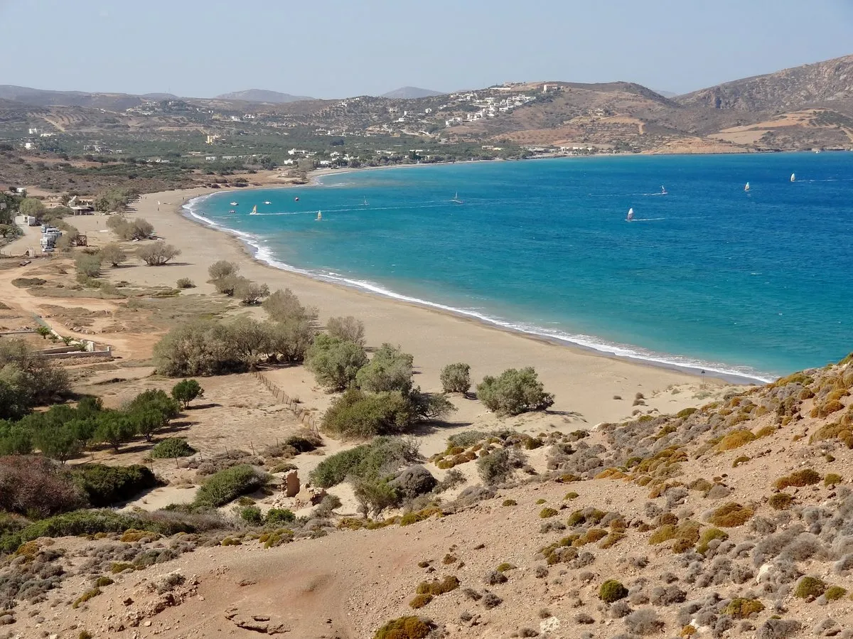 The long arc of Kouremenos bay with sails out on the water