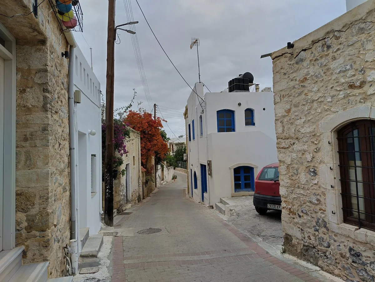 Eine weiß gekalkte Gasse in Koutouloufari unter Bougainvillea