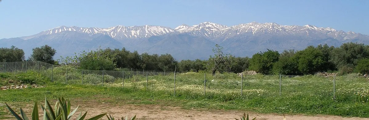 Die schneebedeckten Weißen Berge über den grünen Feldern in der Nähe von Chania