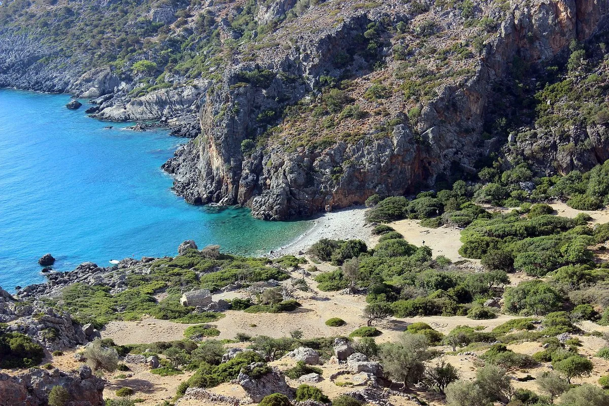 Die Bucht von Lissos vom Weg aus gesehen, mit dem Kiesstrand und der Stätte zwischen den Bäumen