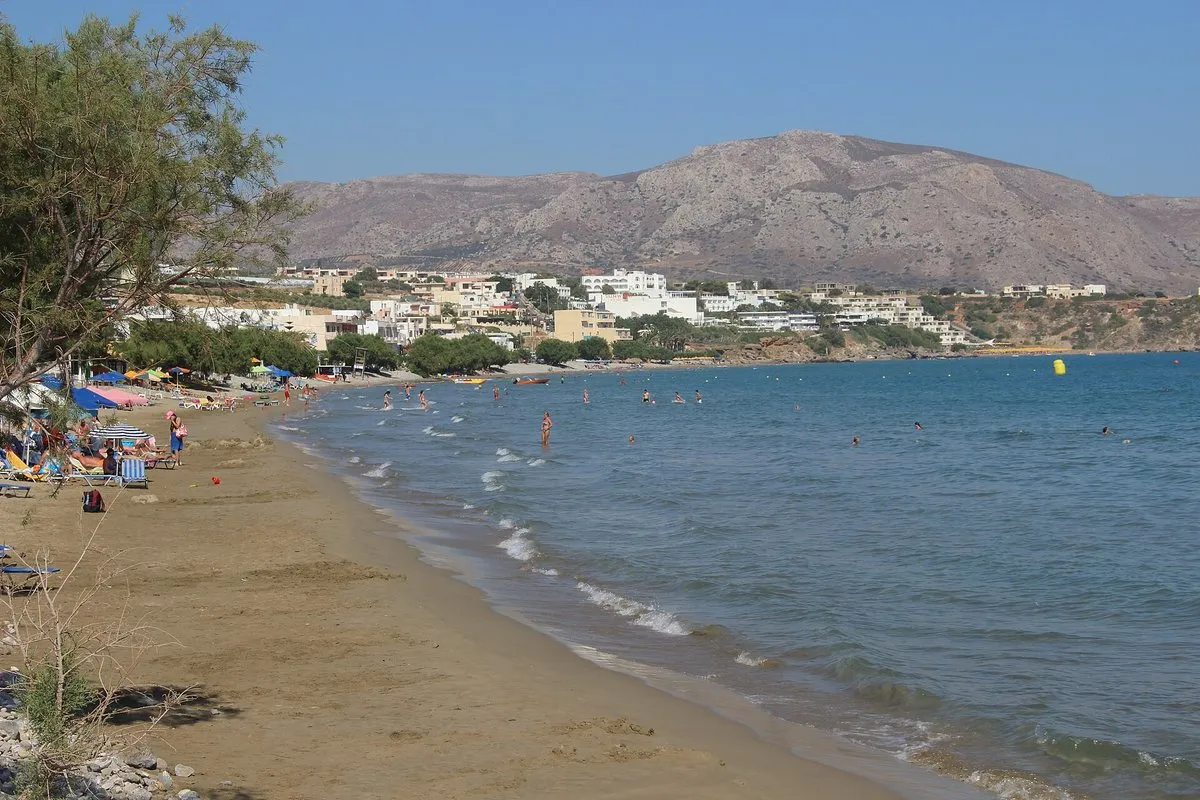 The long shallow sand of Makry Gialos with the village behind