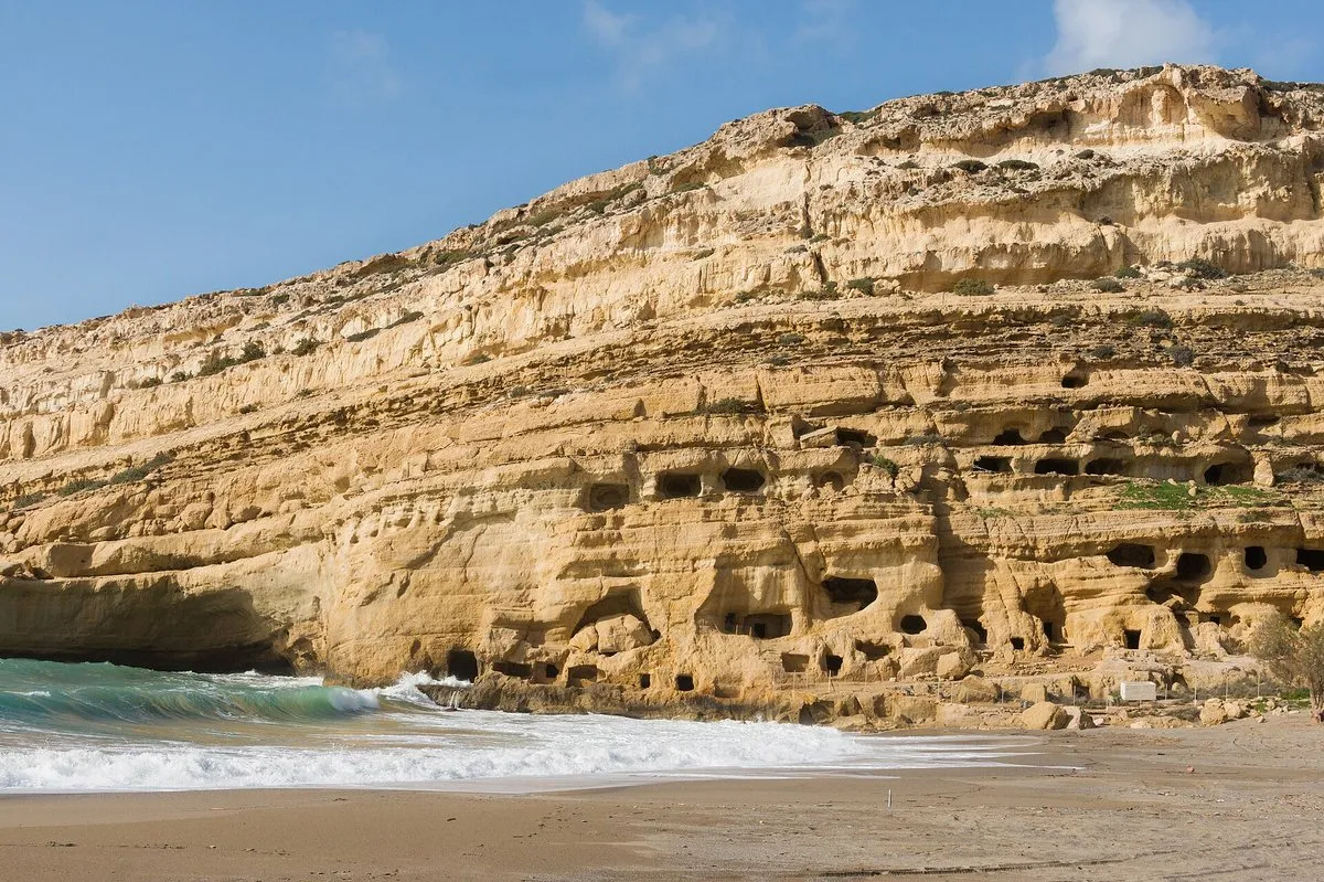 Die gehauene Höhlenklippe über der Wellenlinie in Matala