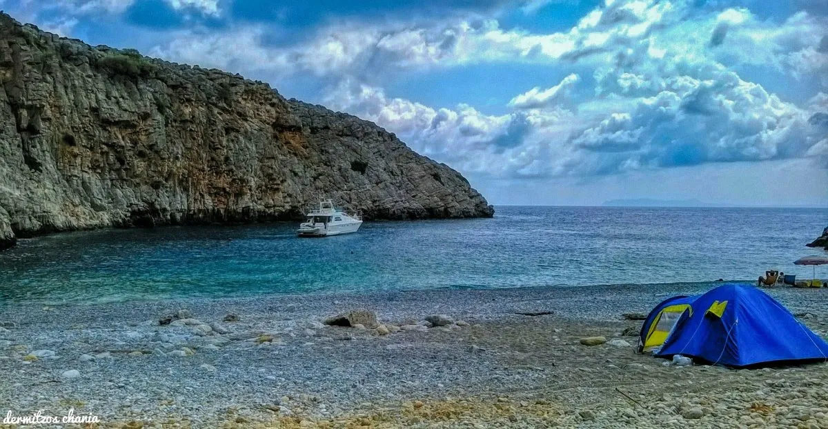 Der Strand von Menies unter hohen Felsen am Ende einer tiefen Bucht auf Rodopou