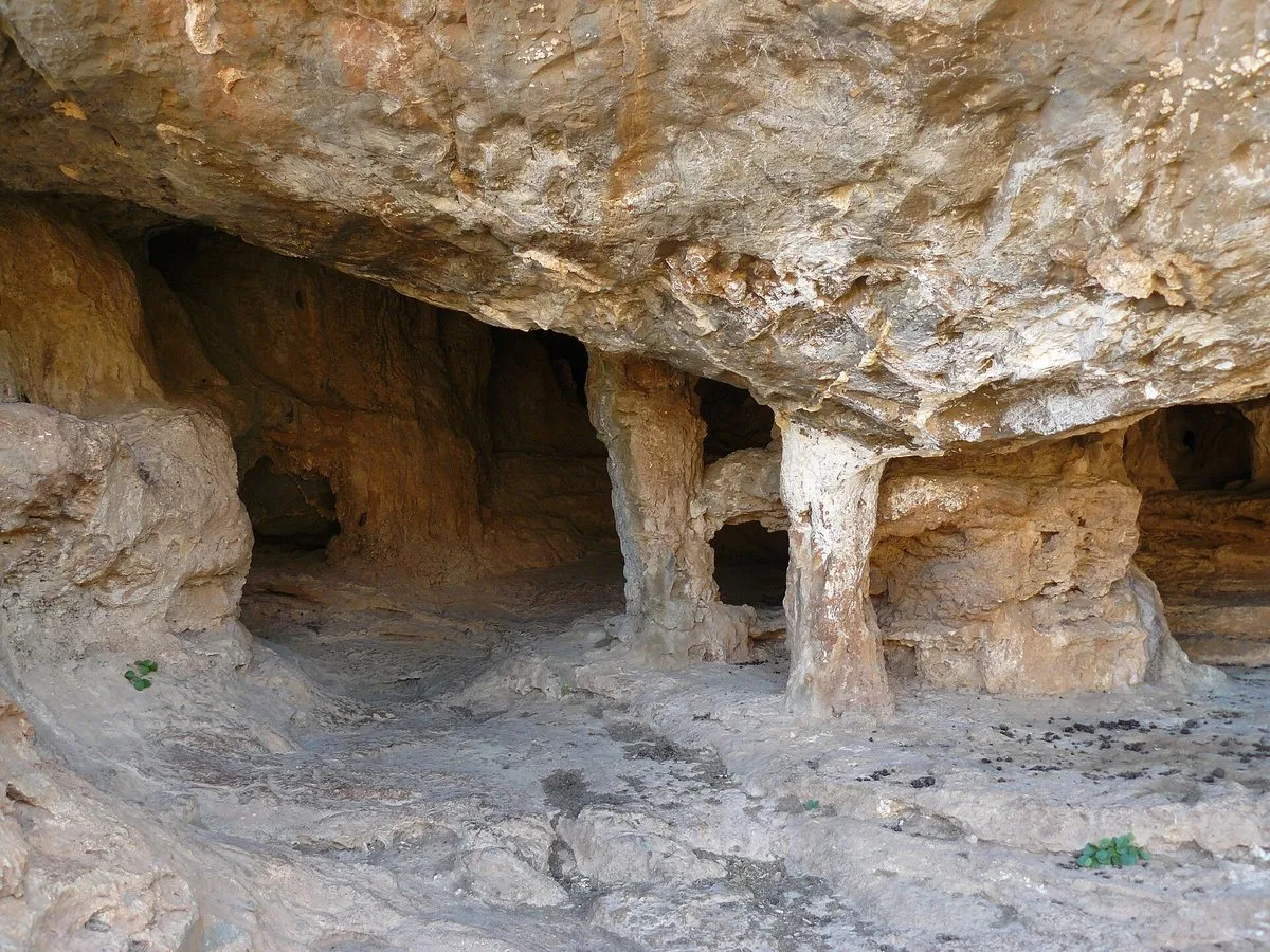 The low, pillared mouth of the cave