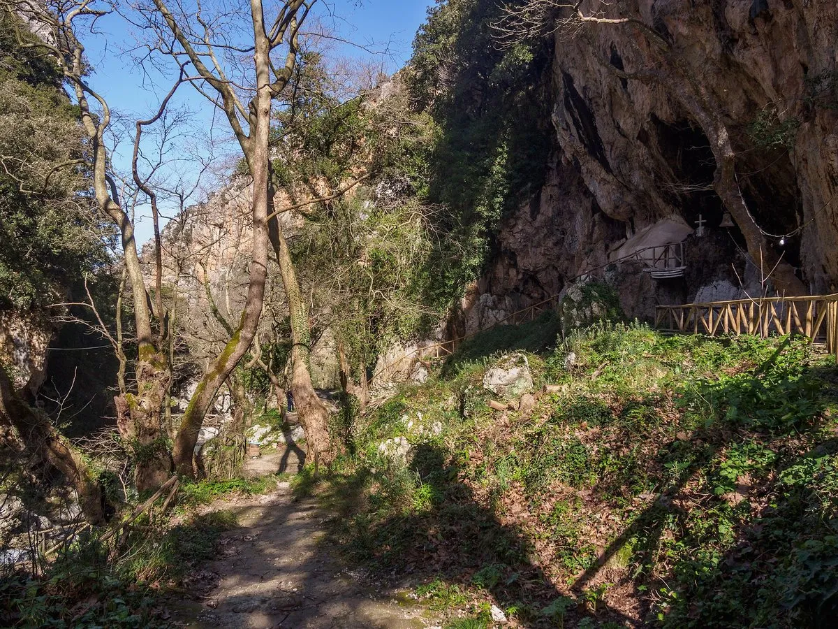 Ein Pfad unter Bäumen am Fuß der Felswände in der Patsos-Schlucht
