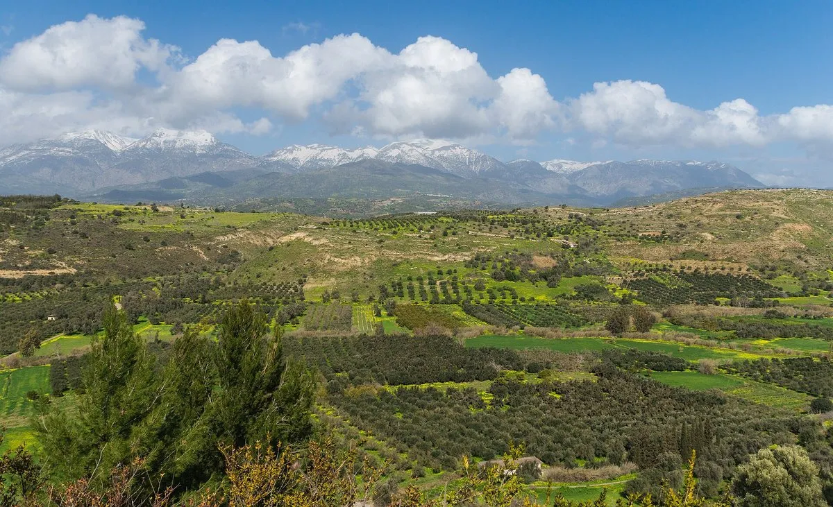 The snow-topped Psiloritis range across the green Messara plain, seen from the ridge at Phaistos