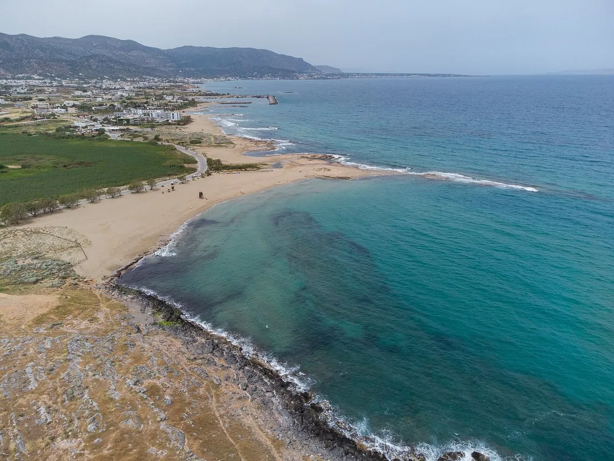 The sandy curve of Potamos at the quiet end of Malia