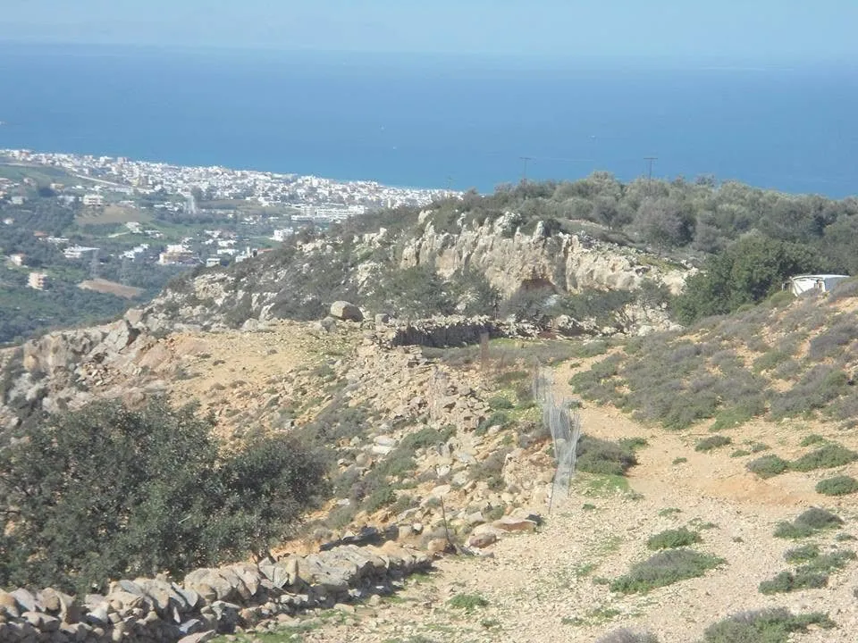 Die trockene, felsige obere Prassiano-Schlucht mit der Stadt Rethymno und dem Meer in der Ferne