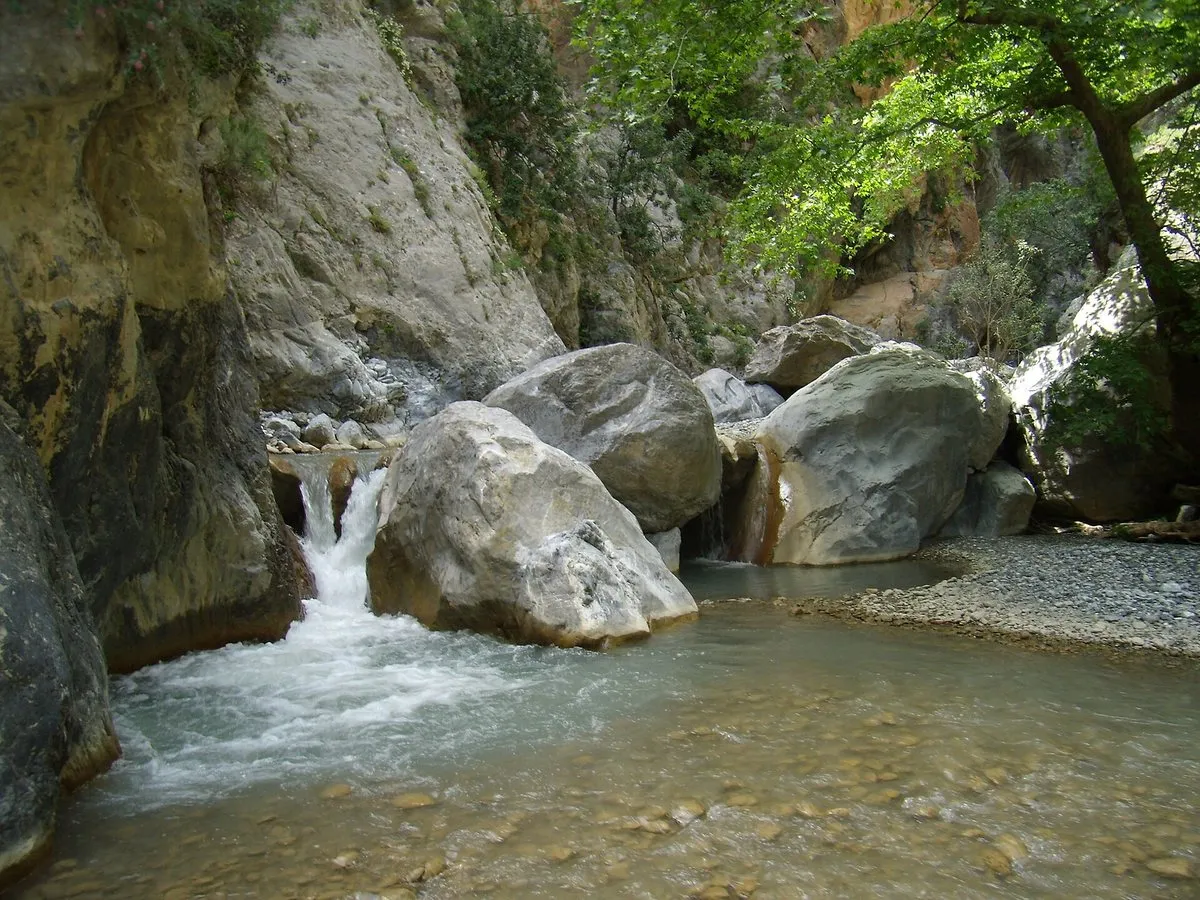 Wasser, das zwischen Felsblöcken in ein Becken der Sarakina-Schlucht stürzt