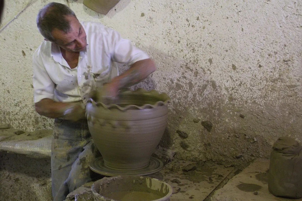 A potter throwing a large jar on the wheel in a Thrapsano workshop
