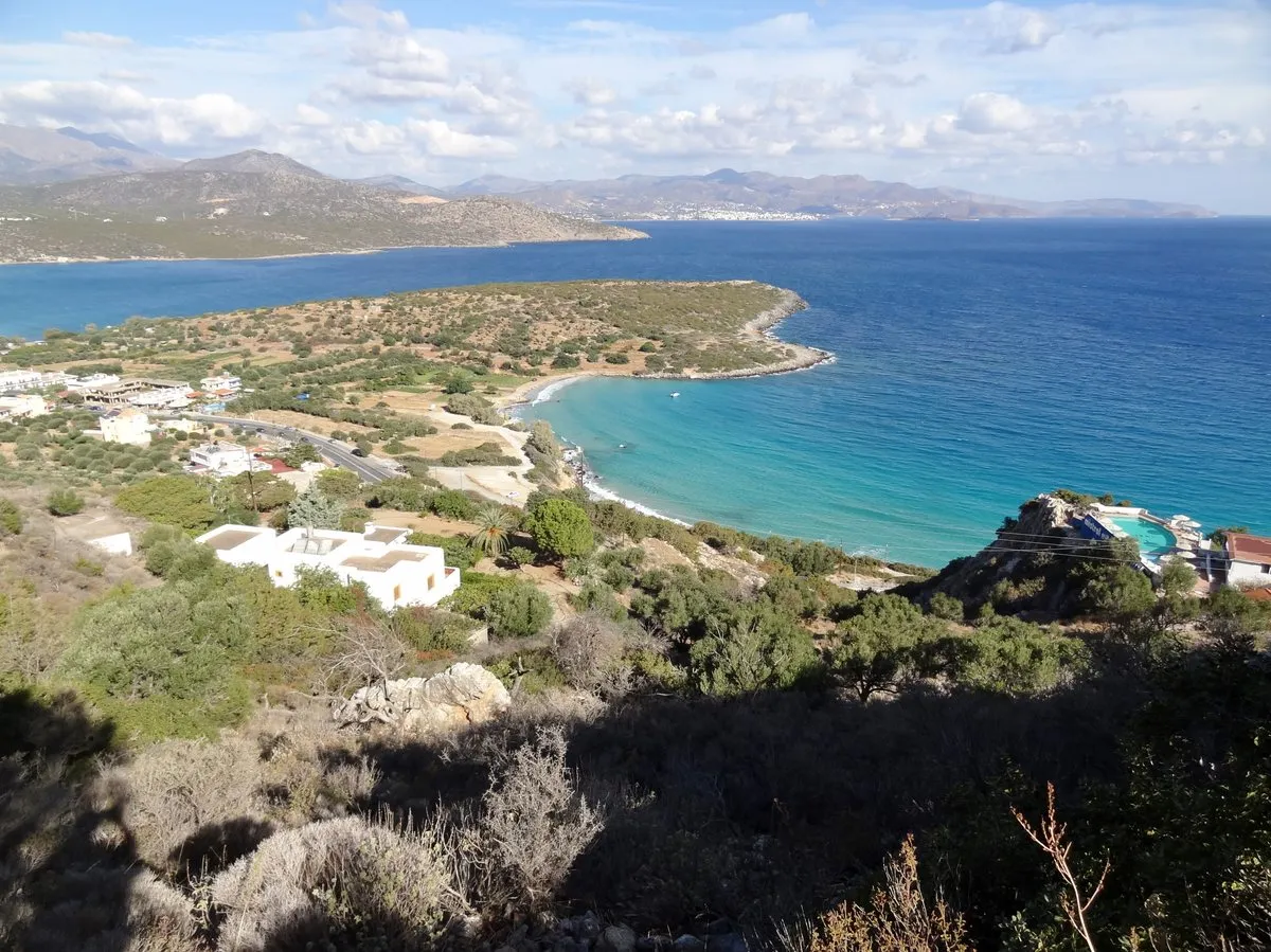 The crescent of Voulisma beach and its pale shallows, seen from the hillside above